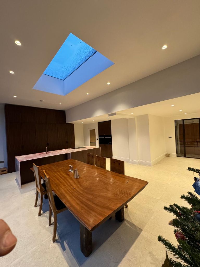 Open plan kitchen diner with skylight and modern electrical fittings